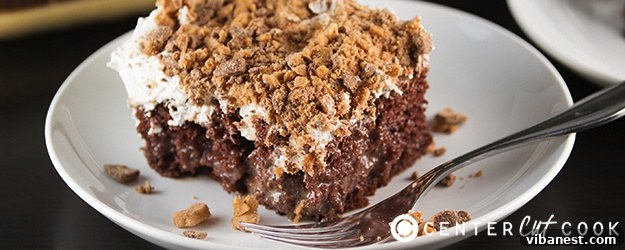 The Ultimate Easy Chocolate Toffee Poke Cake A full Better Than Sex Cake in a rectangular baking dish, topped generously with Cool Whip and a dense layer of Heath bar crumbles.