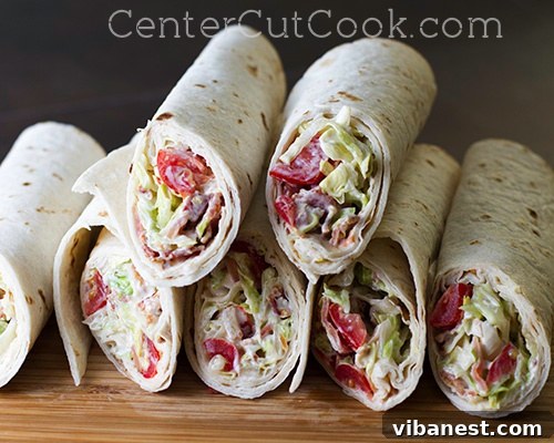 Quick and Easy BLT Wraps Fresh and appealing BLT Wraps cut in half, showcasing layers of crispy bacon, vibrant lettuce, and ripe tomato inside a soft tortilla.