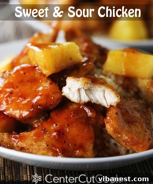 Homemade Sweet and Sour Chicken Recipe Crispy homemade Sweet and Sour Chicken with colorful bell peppers and pineapple chunks, garnished with sesame seeds, served over rice.