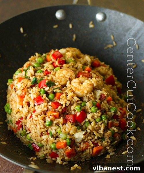 Versatile Chinese Fried Rice Recipe Homestyle Chinese Fried Rice with shrimp, vibrant peas, carrots, and fluffy scrambled egg, expertly garnished with fresh green onions.