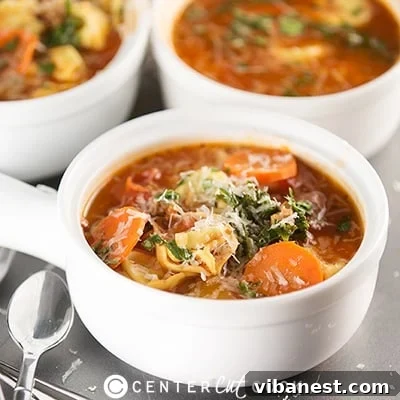 Bowl of Tortellini Soup garnished with fresh herbs and Parmesan