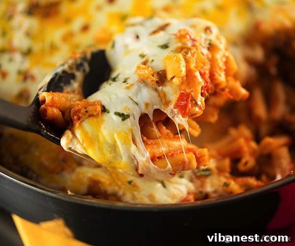 Skillet baked ziti with delicious cheese pull Serving of Skillet Baked Ziti with melted cheese, ready to eat