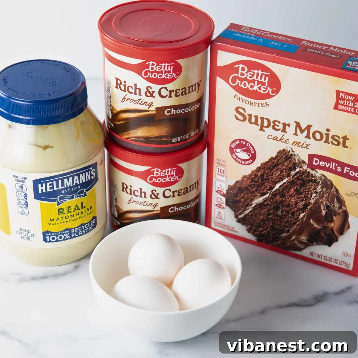 Savor Portillos Legendary Chocolate Cake 5 Ingredients for Portillo's chocolate cake laid out on a counter: cake mix, eggs, mayonnaise, water, and frosting