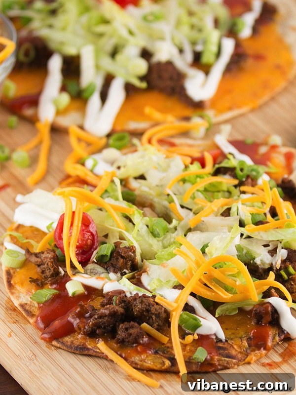 Taco Flatbread Pizzas Ready to Serve Three perfectly baked Taco Flatbread Pizzas arranged on a wooden cutting board, ready for serving