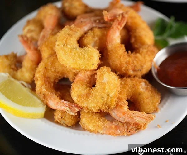 Fried Shrimp with Lemon and Sauce Golden brown crispy fried shrimp served with lemon wedges and cocktail sauce.