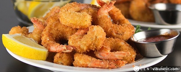 Served Fried Shrimp A large serving of crispy fried shrimp, garnished and ready.