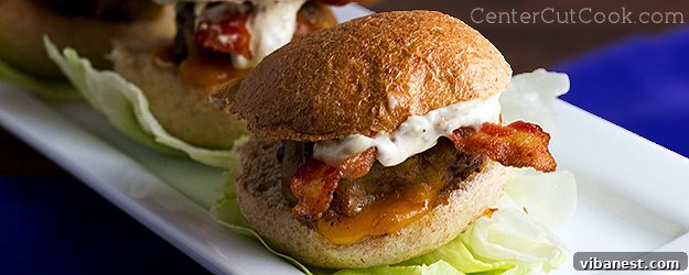 Delicious grilled sliders topped with sharp cheddar cheese and crispy bacon, ready to be served on soft buns.