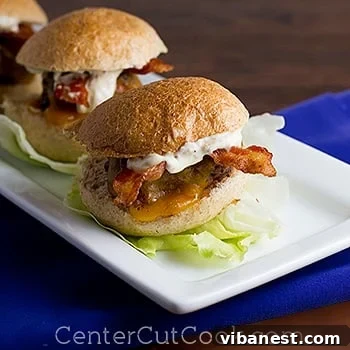 Homemade Grilled Sliders Recipe A close-up shot of grilled sliders with melted cheese, bacon, and special sauce, arranged beautifully on a plate.
