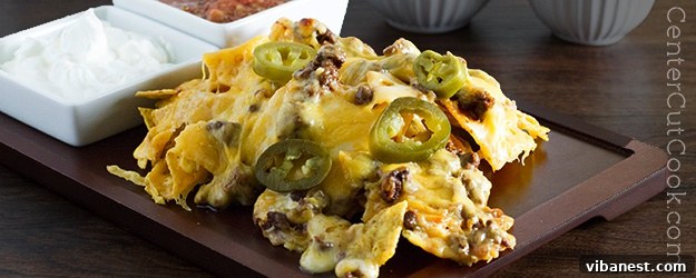 cheesy nachos.jpg A vibrant platter of Cheesy Macho Nachos, laden with melted cheese and seasoned ground beef, ready to be served.