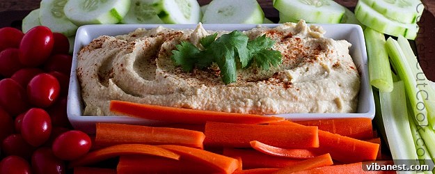 A vibrant bowl of classic homemade hummus, garnished with a swirl of olive oil and a sprinkle of paprika, ready to be served.