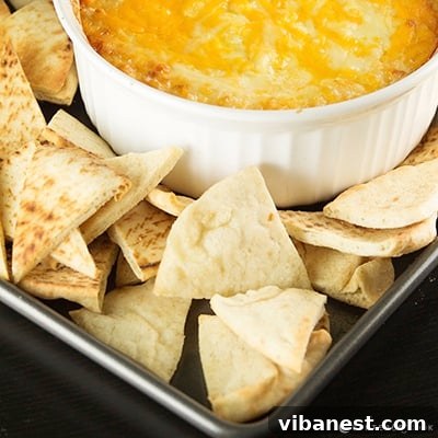Pita Chips and Hummus A bowl of homemade pita chips with a small bowl of hummus in the background.