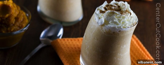Delicious Pumpkin Pie Smoothie topped with a swirl of whipped cream and a sprinkle of cinnamon, ready to be enjoyed.