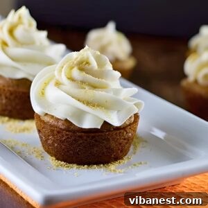 pumpkin pie cupcakes topped with cream cheese frosting and crushed graham cracker crumbs.
