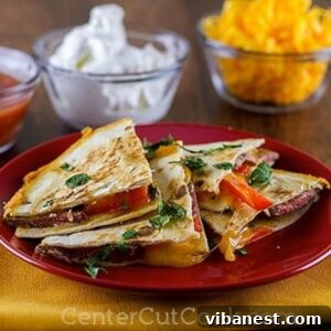 plate of steak quesadillas. Bowls of sour cream and shredded cheese in the background