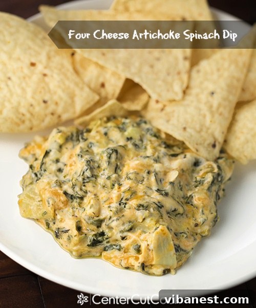 Spinach Artichoke Dip Platter A serving of spinach artichoke dip with a variety of dippers including breadsticks, crackers, and raw vegetables, arranged on a wooden board.