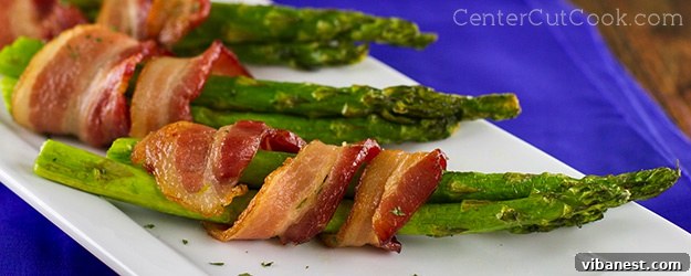 Crispy golden bacon-wrapped asparagus bundles on a platter