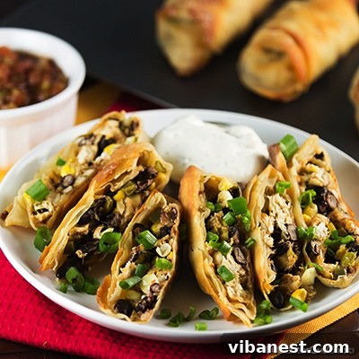 Baked Southwestern Egg Rolls with Dip Baked southwestern egg rolls with dipping sauce on a wooden board