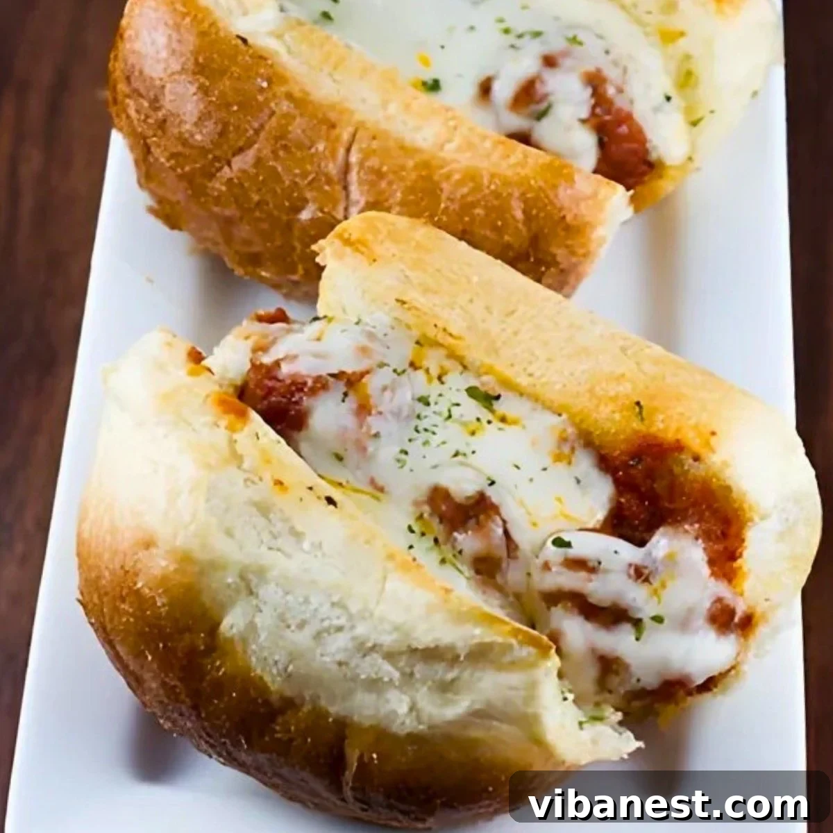 Cheesy Garlic Bread Meatball Melts 2 close-up of garlic bread meatball subs, showing melted cheese and rich sauce