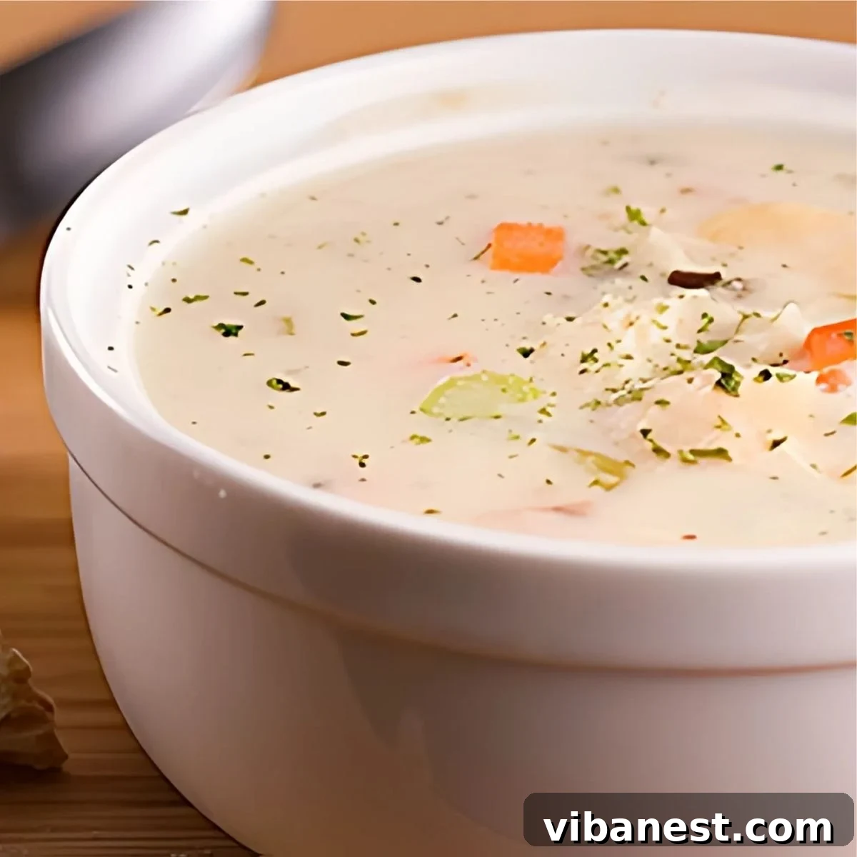 Comforting Slow Cooker Creamy Chicken and Wild Rice Soup 2 A steaming bowl of creamy chicken and wild rice soup, garnished with fresh parsley.