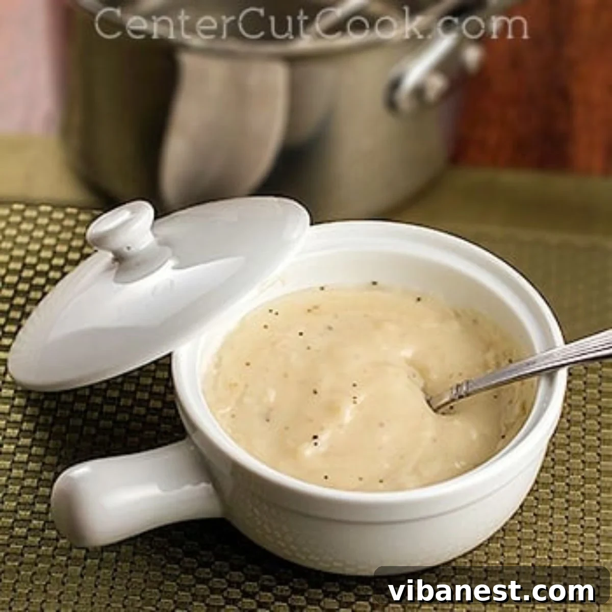 Mastering Cream-Free Creaminess 6 Bowl of homemade cream soup substitute with a spoon and lid, perfect for storage or meal prep.