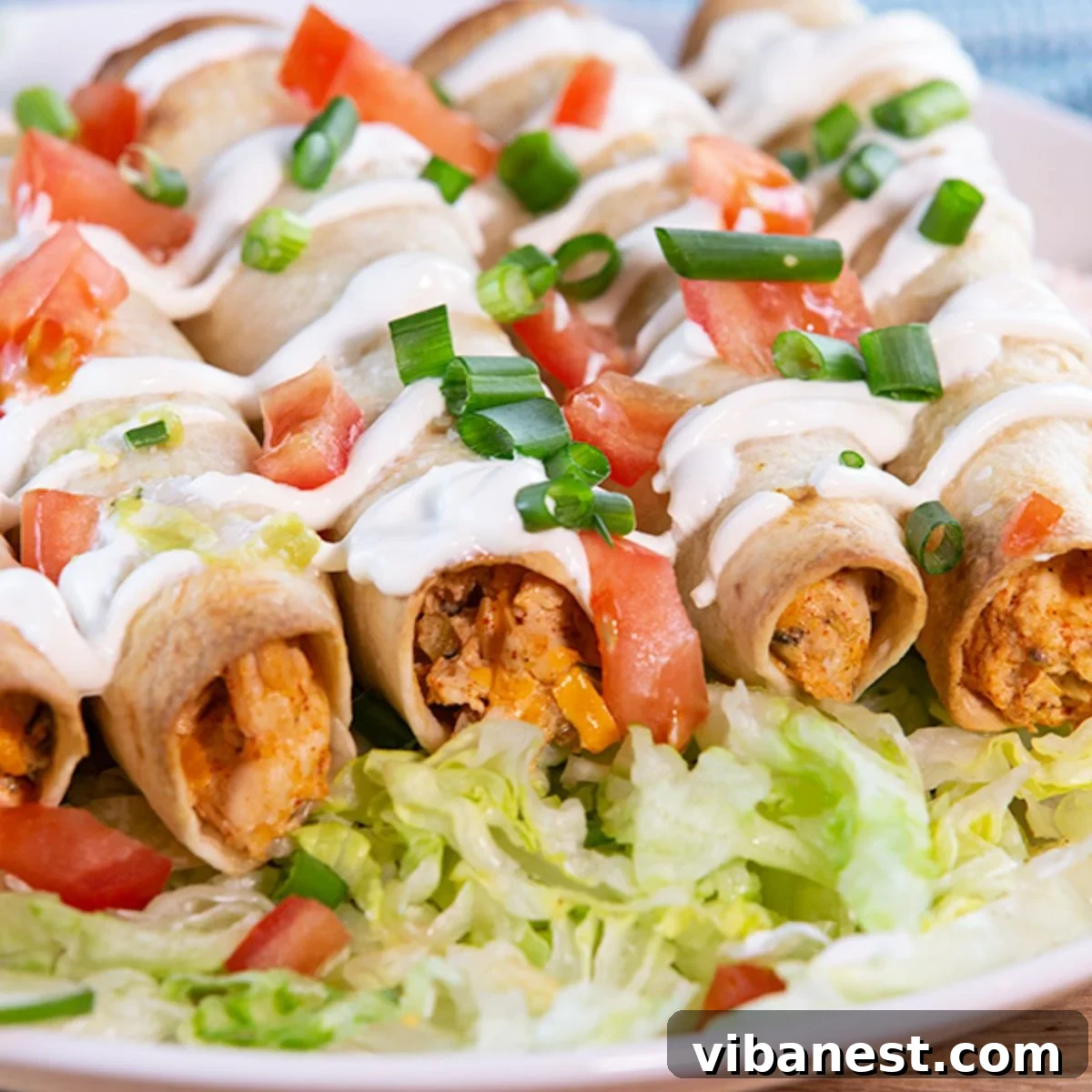 Lean and Luscious Taquito Rolls 2 Crispy oven-baked creamy chicken taquitos arranged on a plate with garnishes.