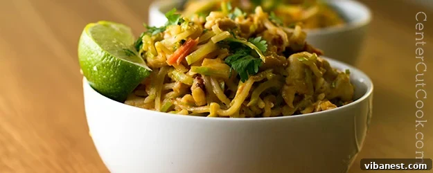 Delicious Chicken and Veggie Noodle Bowl with creamy Peanut Sauce, garnished with fresh cilantro and lime