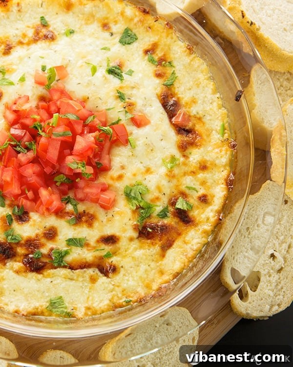 Served Smoked Mozzarella Fonduta with bread. Smoked Mozzarella Fonduta appetizer with toasted bread slices arranged around the dish.