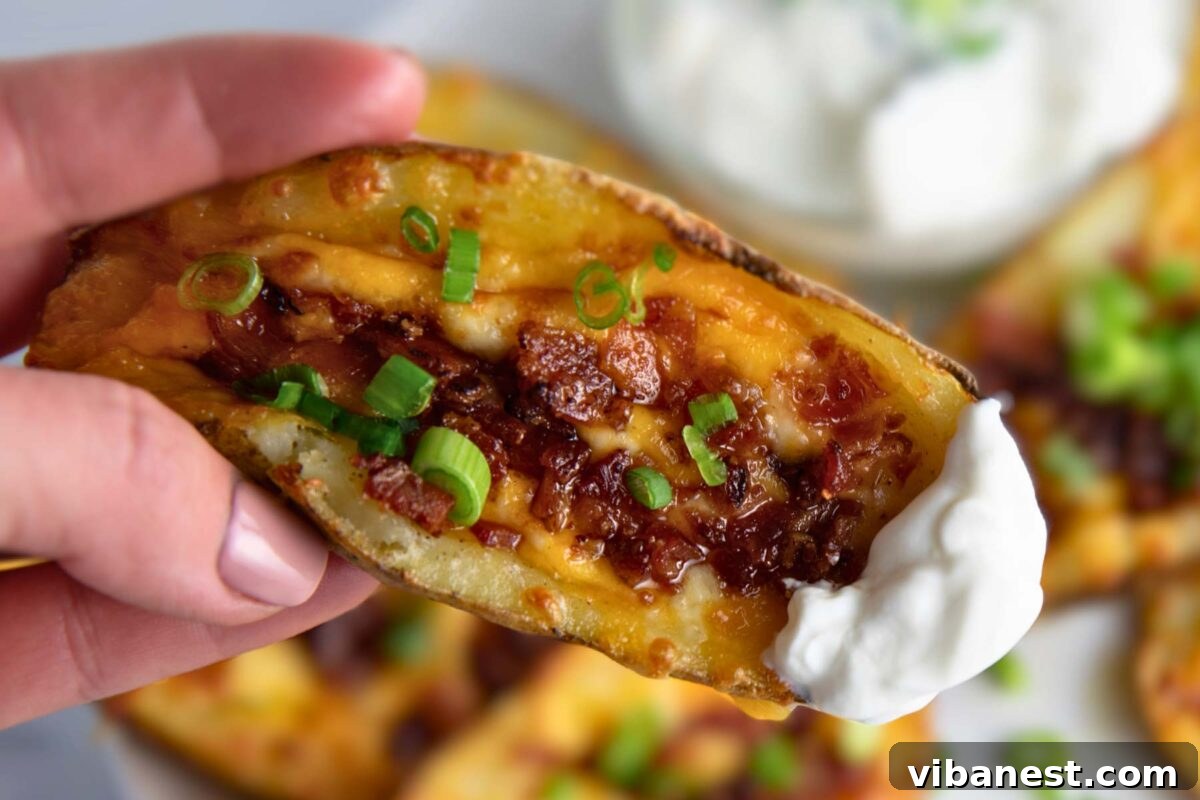 Fully Loaded Potato Boats 13 A close-up shot of a single loaded potato skin with all its toppings, emphasizing its appetizing appearance.