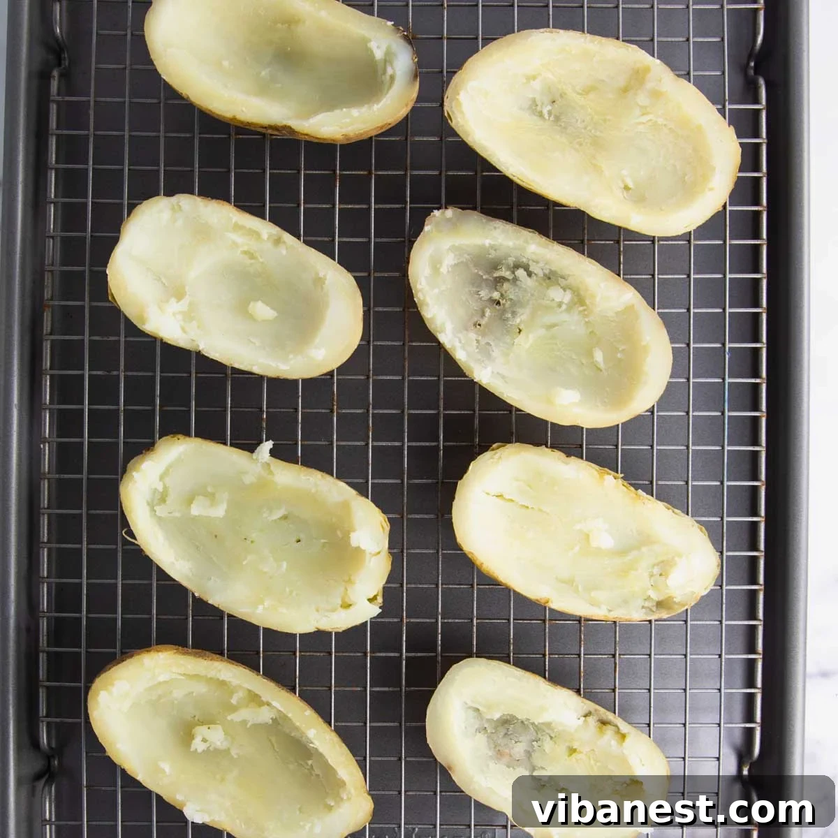 Fully Loaded Potato Boats 7 Potato skins lightly brushed with melted butter and seasoned with salt and pepper, arranged on a baking sheet, ready for the broiler.