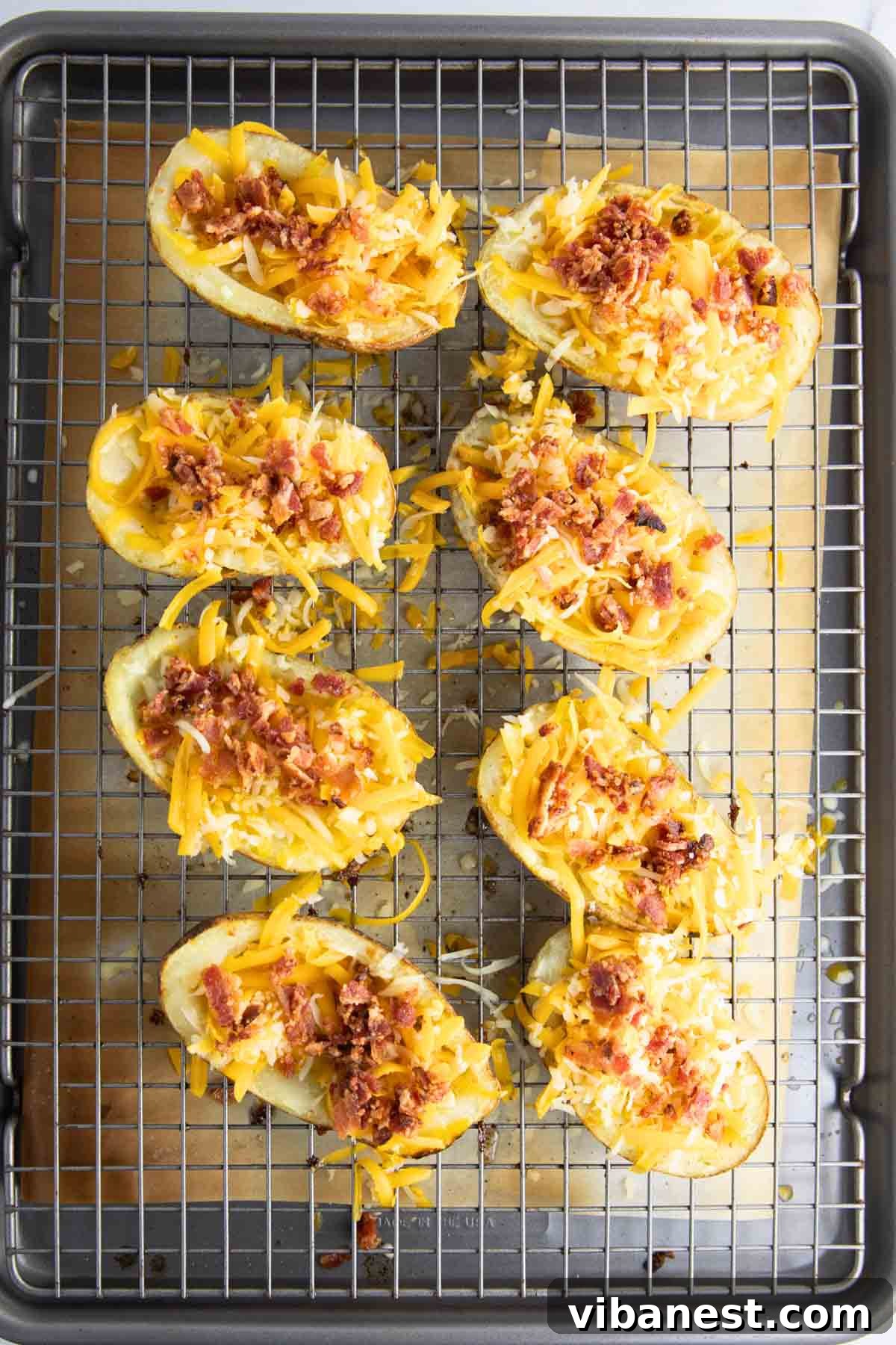 Fully Loaded Potato Boats 10 Potato skins generously topped with shredded cheddar cheese and crispy bacon, ready to go back into the broiler.