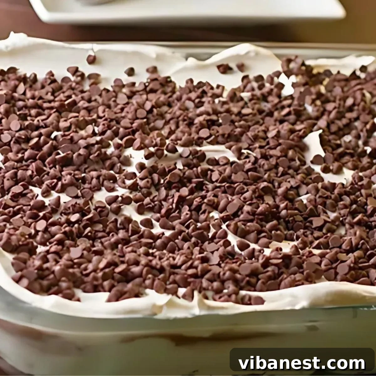 Decadent Chocolate Stack 3 Close-up shot of no-bake chocolate lasagna in a 9x13 inch baking dish, showing distinct layers of chocolate pudding and whipped cream.