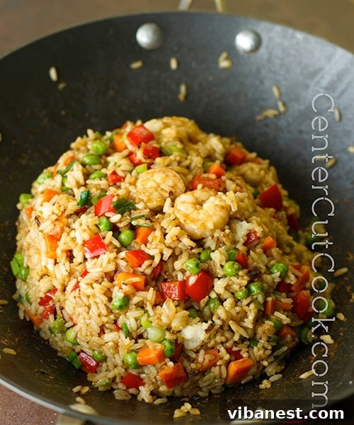 A vibrant bowl of chicken fried rice, garnished with fresh herbs. fried rice with chicken