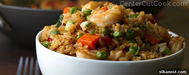A perfectly cooked bowl of Chinese fried rice with succulent shrimp. bowl of fried rice with shrimp