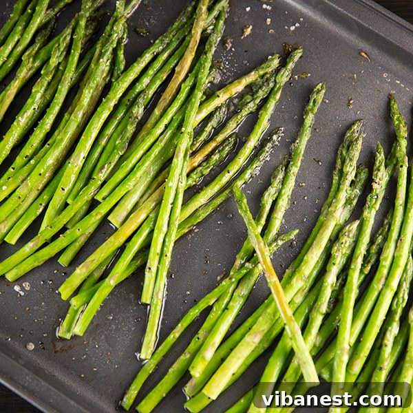 Gourmet Roasted Asparagus Close-up of roasted asparagus garnished with melted Parmesan cheese and a hint of lemon.