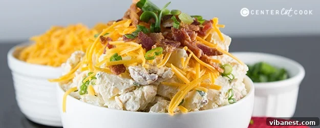 loaded baked potato salad.jpg Top-down shot of a generously garnished large bowl of Loaded Baked Potato Salad on a rustic wooden table