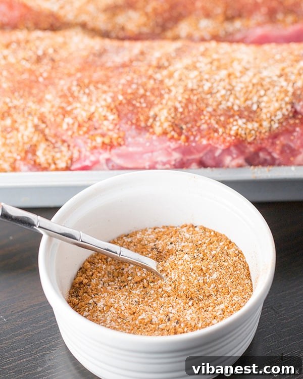 Dry Rub for Ribs and Chicken 6.jpg Dry Rub for Ribs and Chicken 6 - A spoon scooping the vibrant dry rub from a bowl.