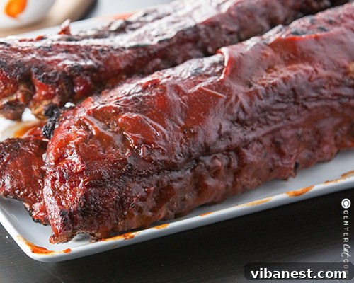 Seasoned Baby Back Ribs A rack of seasoned pork baby back ribs, generously coated with dry rub, ready to be placed on the grill.