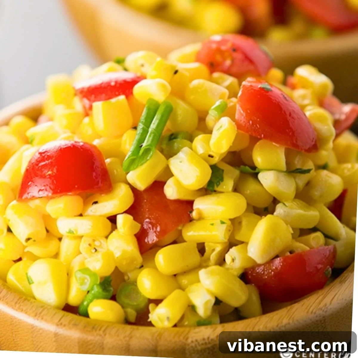 Vibrant Summer Corn Salad 2 A vibrant bowl of fresh summer corn salad with sweet corn, halved cherry tomatoes, sliced green onions, and fresh cilantro leaves.