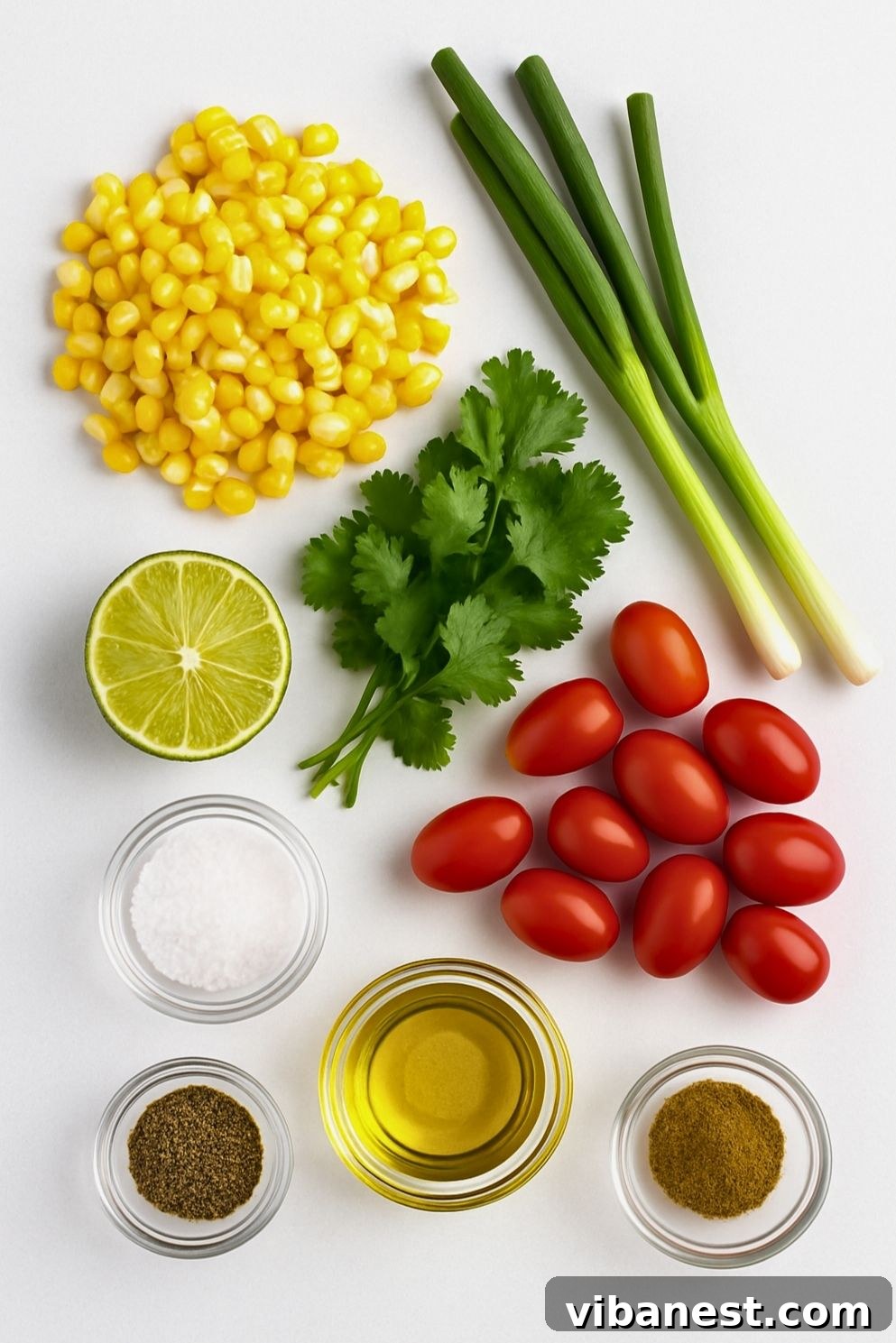 Vibrant Summer Corn Salad 4 Individual ingredients laid out for summer corn salad including fresh sweet corn, vibrant cherry tomatoes, fresh cilantro, and sliced green onions.