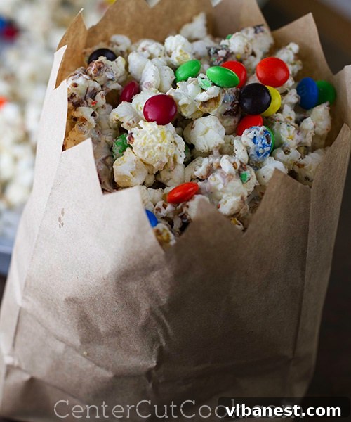 Close-up of freshly made white chocolate popcorn with M&M's on a baking sheet, ready to set