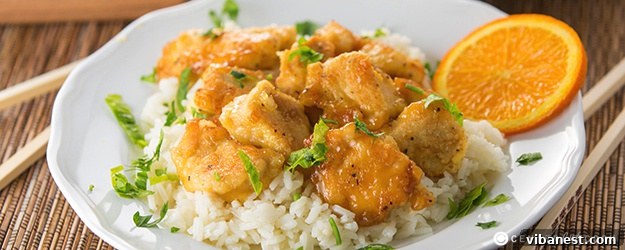 Delicious Homemade Orange Chicken served with fresh orange slices and green onions