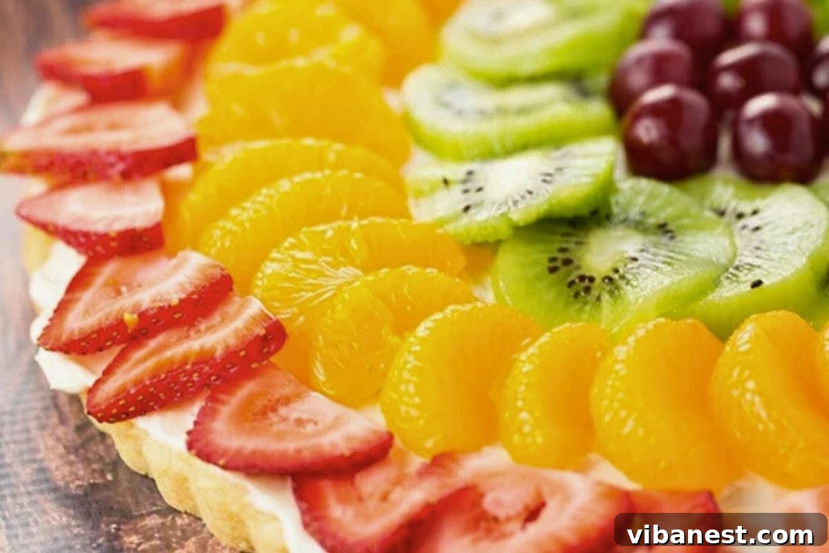 Rainbow Fruit Dessert Pizza 6 close-up of a slice of fruit pizza with cream cheese frosting.