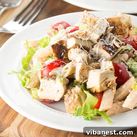 Caesar Pasta Salad Ready to Serve Bowl of homemade Caesar Pasta Salad with fresh greens and chicken