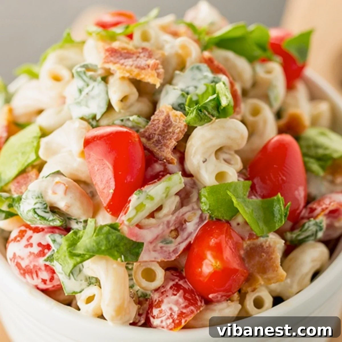 Smoky BLT Pasta Salad 2 A vibrant BLT pasta salad featuring crispy bacon, bright cherry tomatoes, fresh spinach, and creamy dressing, served in a rustic bowl.