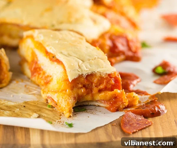 Pepperoni Pizza Bread Baked Baked Pepperoni Pizza Bread Roll-Up, golden brown and ready to be sliced