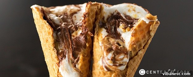 Finished campfire cones. A perfectly melted Campfire Cone with s'mores ingredients spilling out slightly.