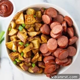overhead of bowl of air fryer kielbasa and potatoes with a side of ketchup